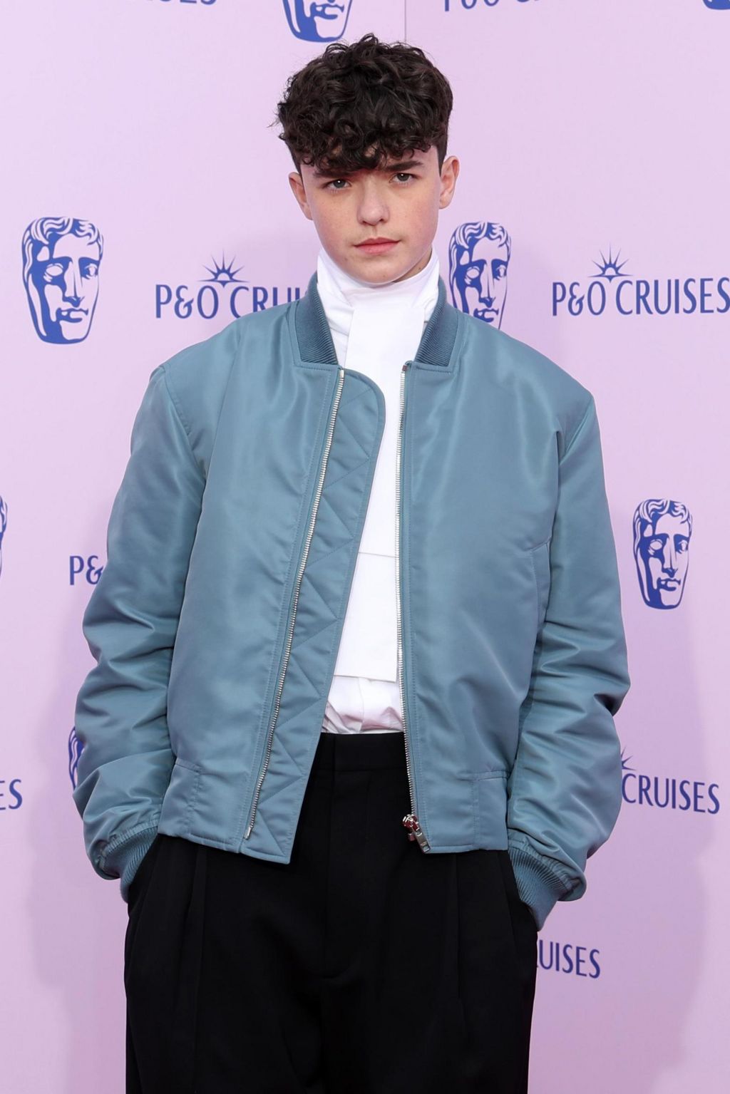 Owen Cooper in a blue casual jacket, white shirt and dark trousers