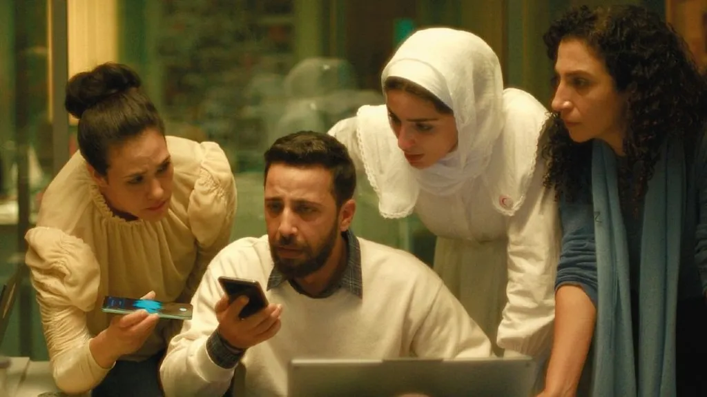 A group of staff in a call centre, crowding around a mobile phone