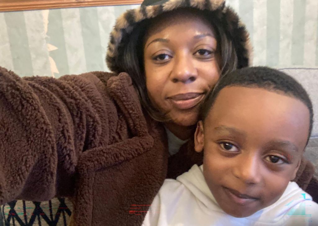 Boy in white top (right) with a woman in brown fleece