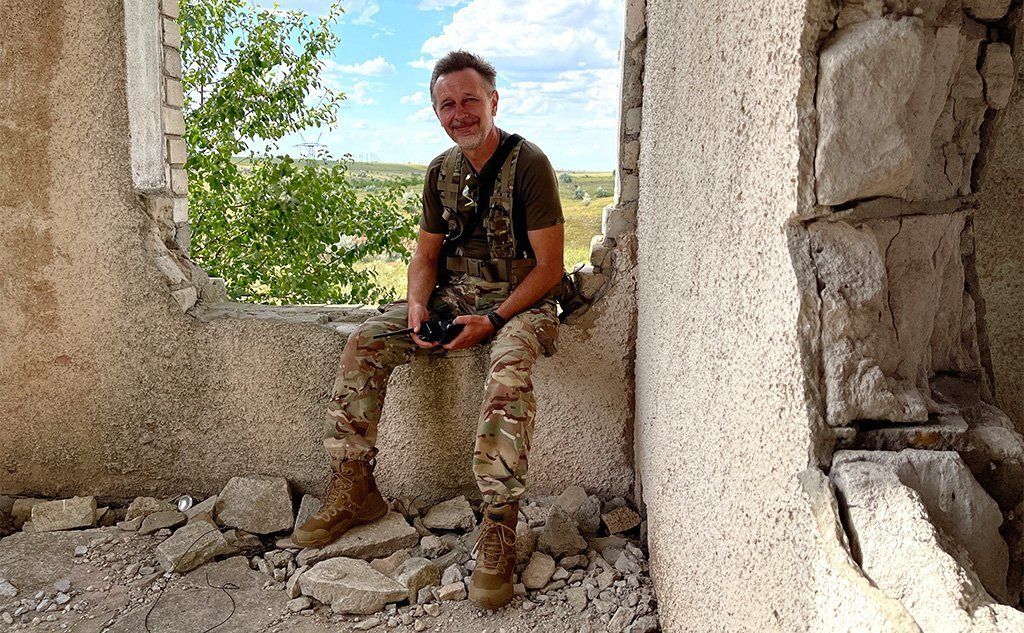 Serhii sits in a ruined building