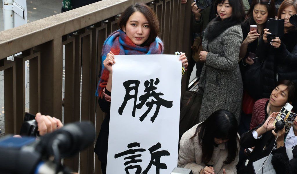 Shiori Ito holds up sign showing victory in front of the Tokyo District Court on December 18, 2019 in Tokyo, Japan. A Tokyo court awarded 3.3 million yen (US$30,000) in damages to journalist Shiori Ito, who accused a former TV reporter of rape in one of Japanese #MeToo movement cases.