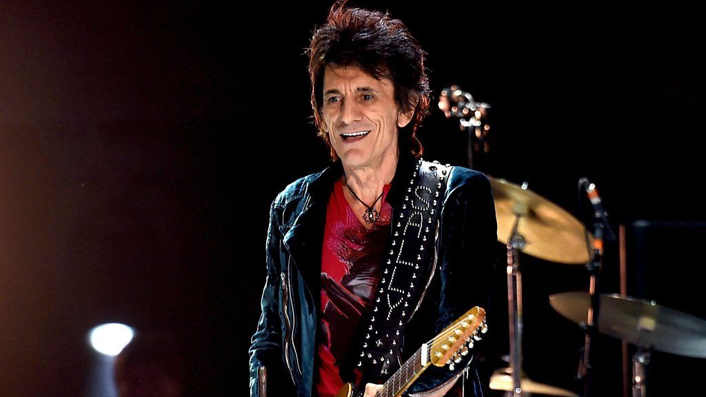 Ronnie Wood playing guitar on stage