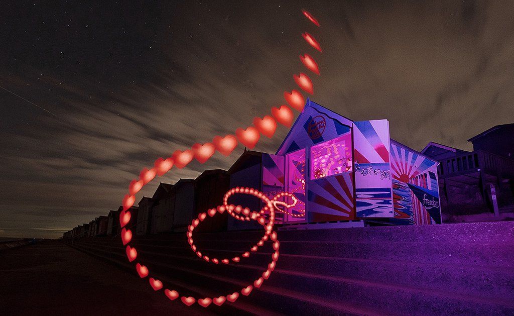 Red heart light trail spills from the seahorse beach hut at Walton in Essex, painted by Norfolk-based artist Samuel Thomas