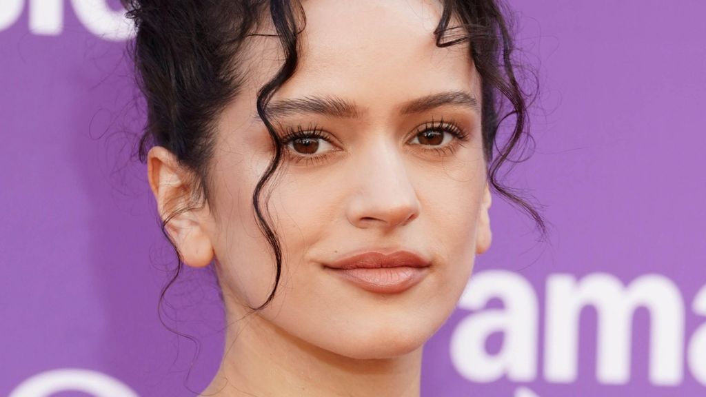 A close-up of Rosalia on the red carpet, with strands of curly hair falling down over her face