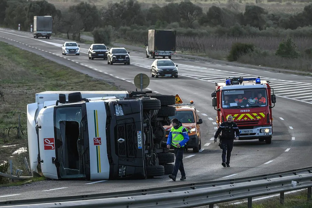 A lorry cab lies on its side in the road