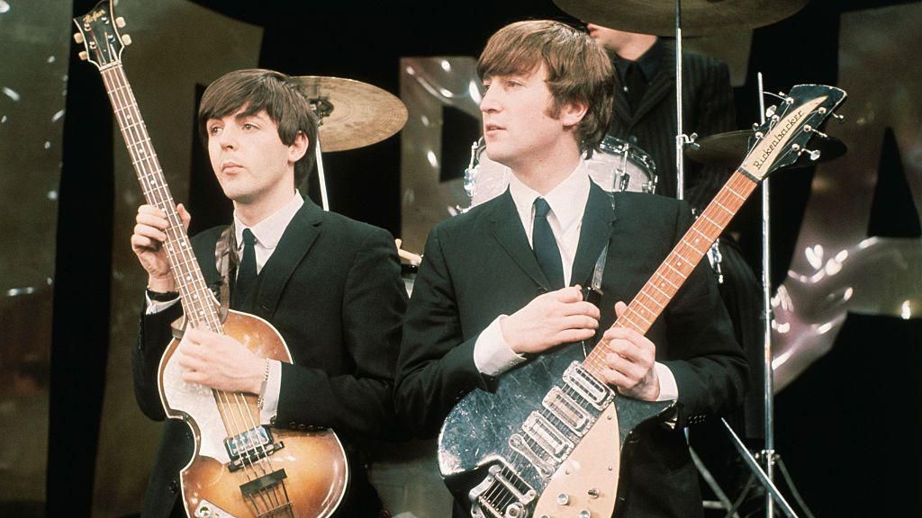 British Rock musicians Paul McCartney (left) and John Lennon perform on the set of 'The Ed Sullivan Show' in 1964. The photo was taken during rehearsals for the group's debut performance on the show the following day