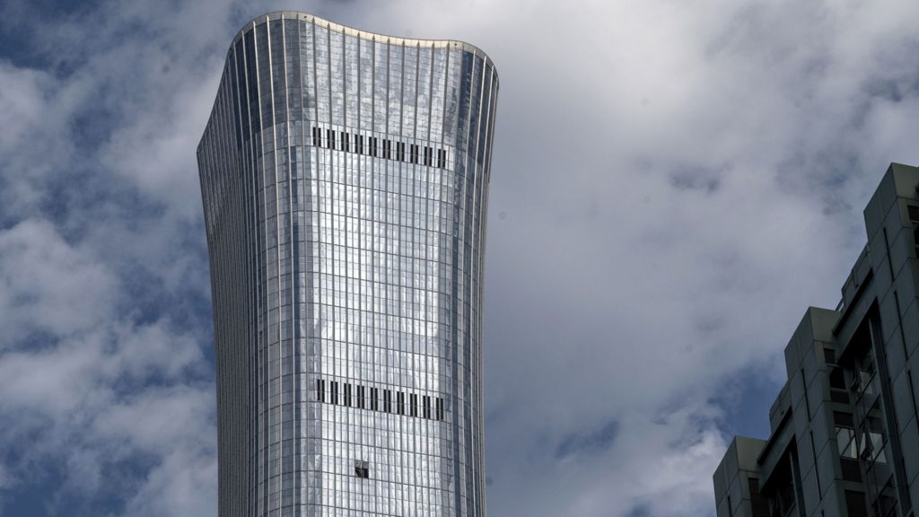 Side view of the top of CITIC tower in Beijing China, showing a hole where a small plane had crashed into