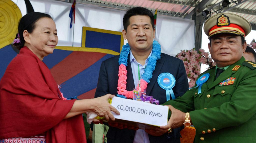 She Zhijiang with Saw Chit Tu and a woman accepting a cheque