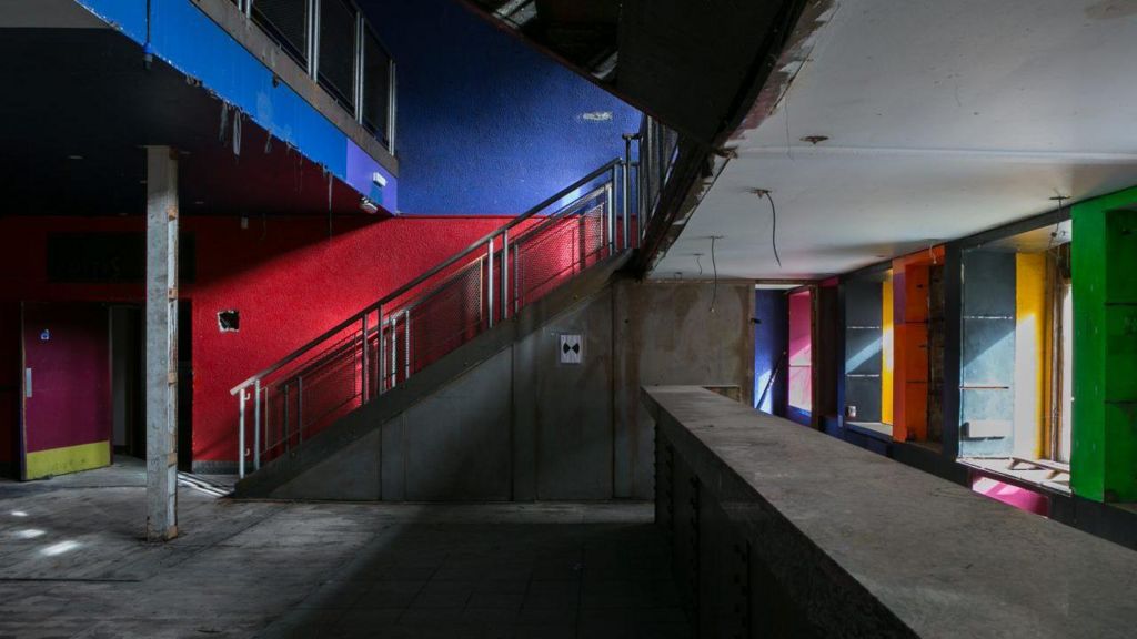 Empty nightclub space with concrete floors and walls, painted in bright colours