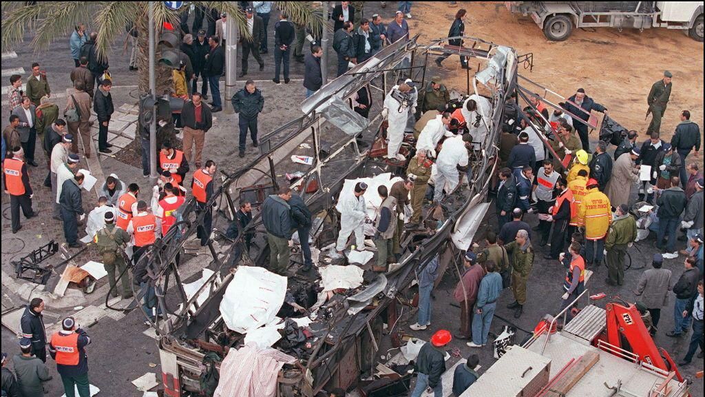 Israeli rescue teams search for bodies of victims inside the wreckage of a bus which was destroyed 03 March 1996 by a suicide bomber in central Jerusalem. At least 20 Israeli were killed in the blast. 