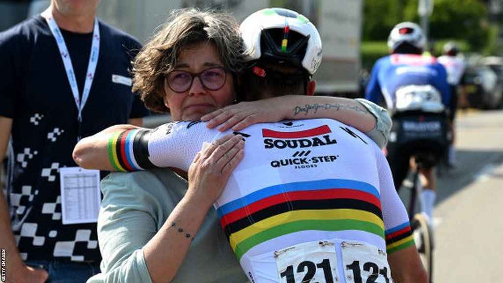 Heidi Mader is consoled by cyclist Remco Evenepoel following the death of her son Gino during the 2023 Tour de Suisse