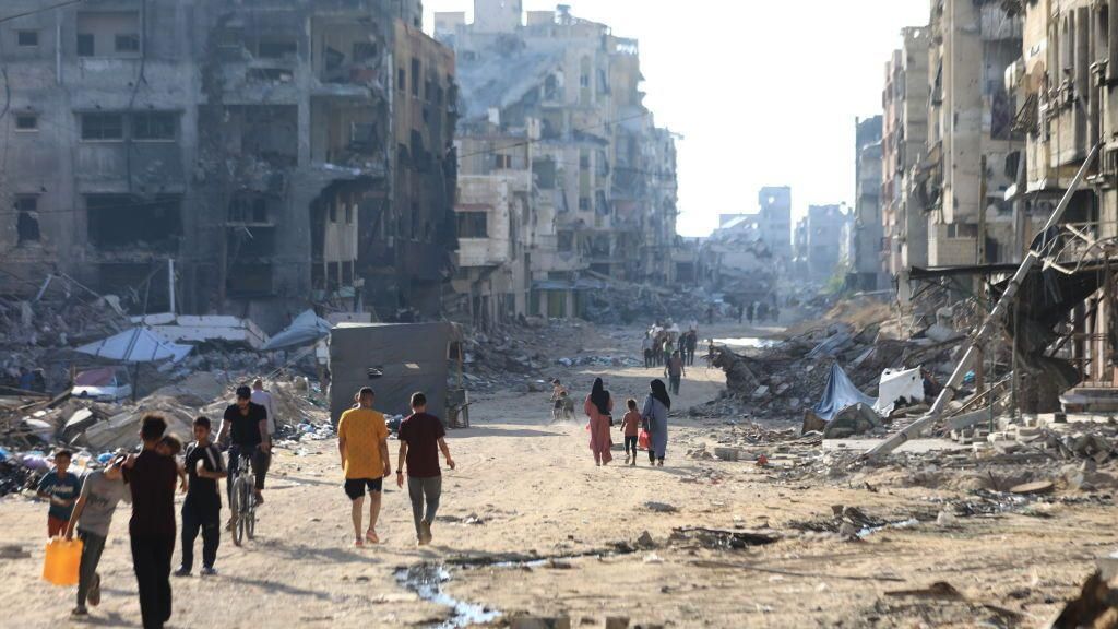 Palestinians walk through a street in north-western Gaza City (9 July 2024)