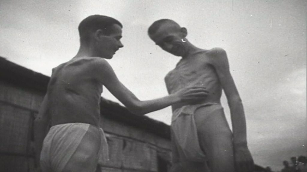 Two starving prisoners of war in loin cloths