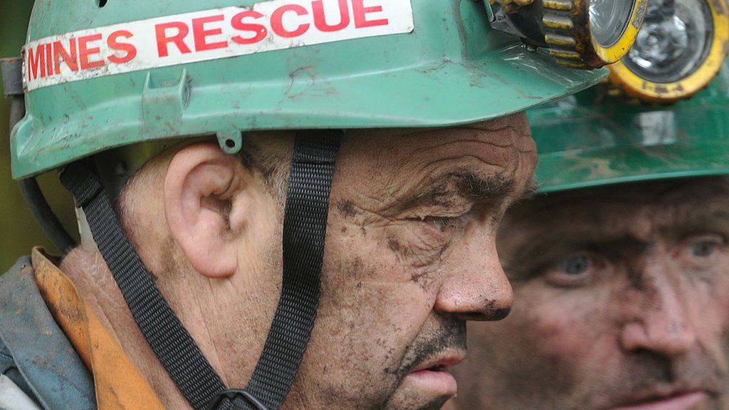 Two mine rescue workers leave the Rhos community centre
