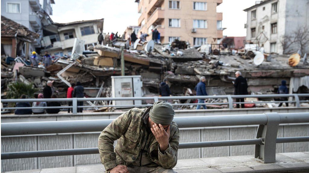 Soldier sitting near quake rubble in Hatay, Turkey