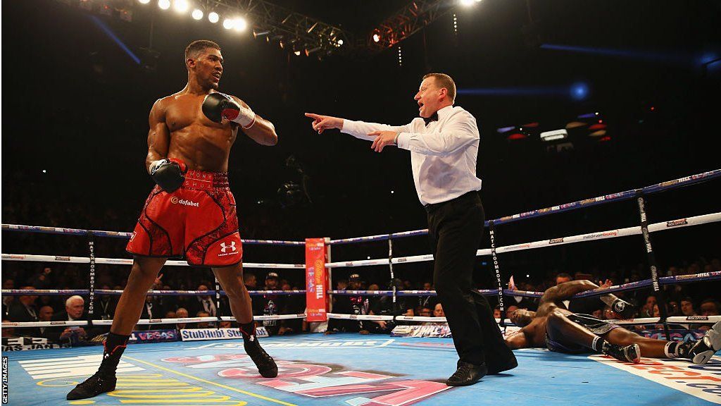 Anthony Joshua is backed up by referee Howard Foster after knocking down Dillian Whyte