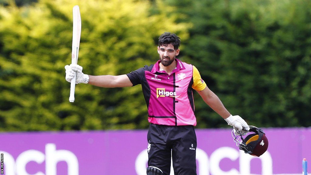 Andy Umeed raises his bat as he leaves the field from a Somerset match last season