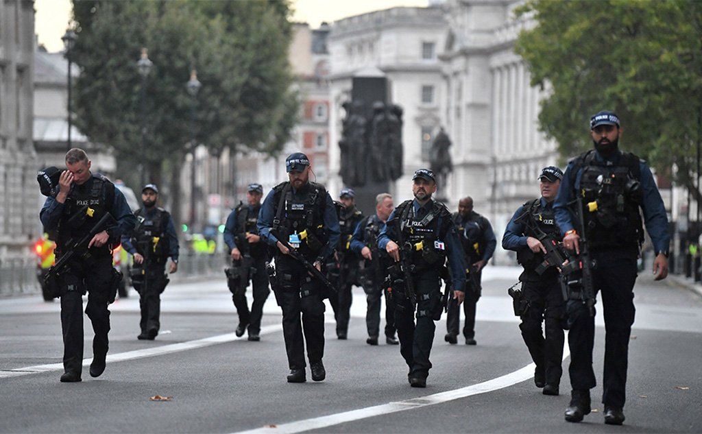 Armed police officers patrol the streets ahead of the procession to carry the body of Britain's late Queen Elizabeth II from Buckingham Palace to Westminster Hall, London,14 September 2022