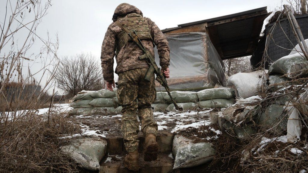 A Ukrainian Serviceman walks in the trenches at a frontline position