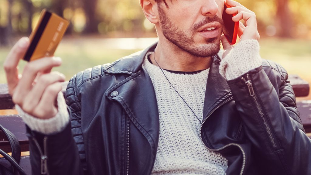 A man on the phone holding a credit card