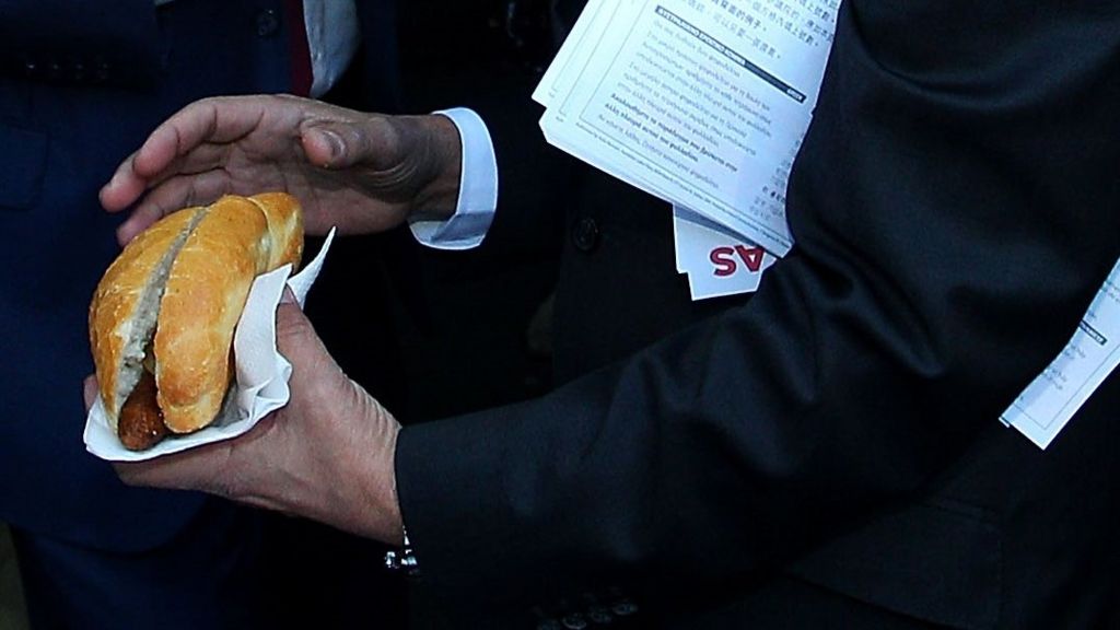 Politician holds a sausage in a bun at Australia's election