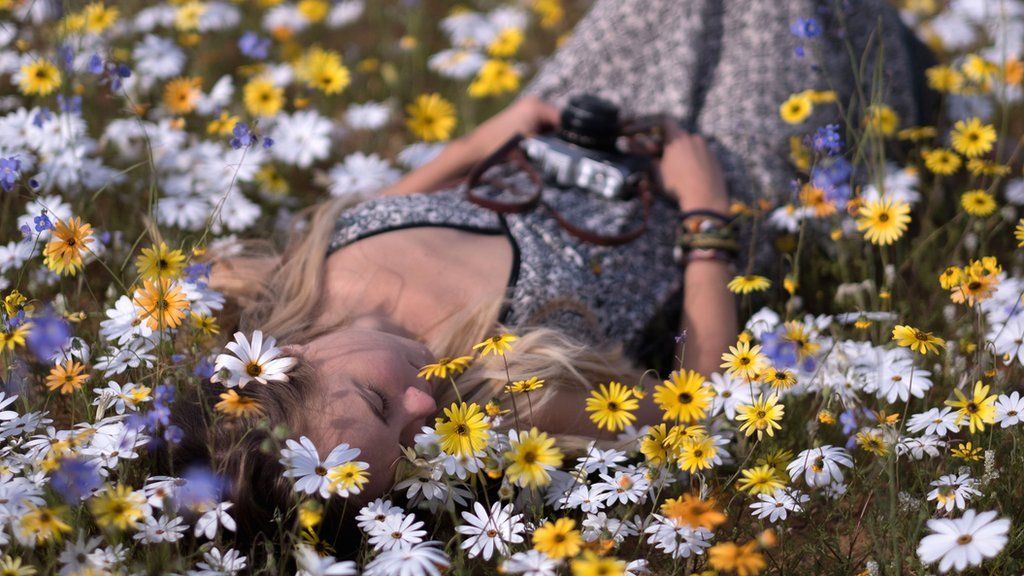 A woman lying on the ground among flowers