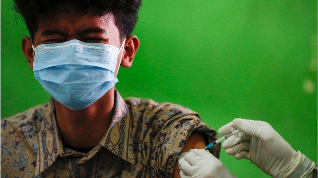 An Indonesian student reacts as he receives his first dose of China's Sinovac Biotech vaccine for the coronavirus disease (COVID-19) at a high school, as the cases surge in Jakarta, Indonesia, 1 July 2021.