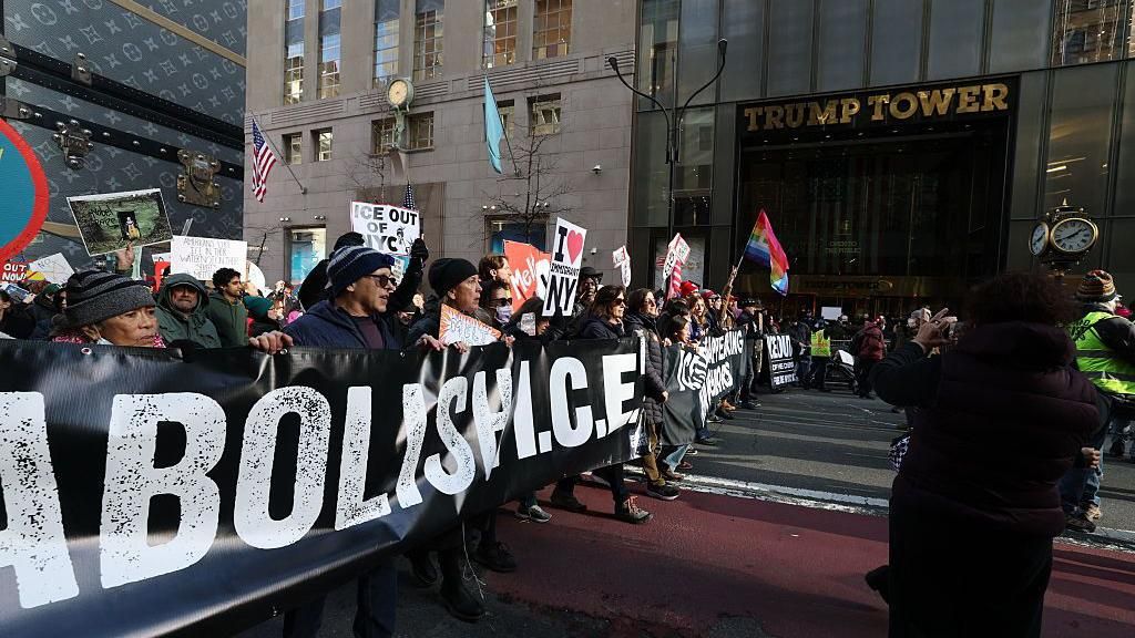 People hold signs outside the Trump tower as they participate in a protest organized by Rise and Resist against US Immigration and Customs Enforcement (ICE) activities and the US intervention in Venezuela in New York on January 11, 2026