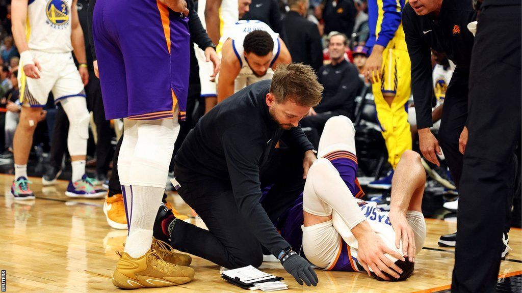 Jusuf Nurki on the floor after being hit by Draymond Green