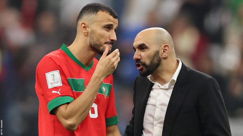 Romain Saiss speaks to Morocco coach Walid Regragui at the 2022 World Cup in Qatar