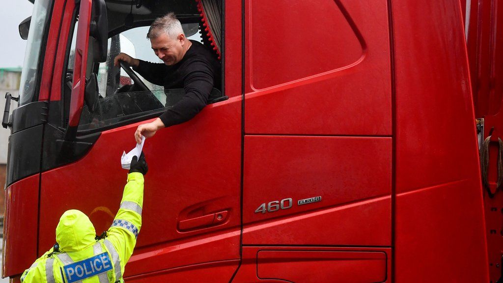 Police officer checking the documentation of a lorry driver at Dover