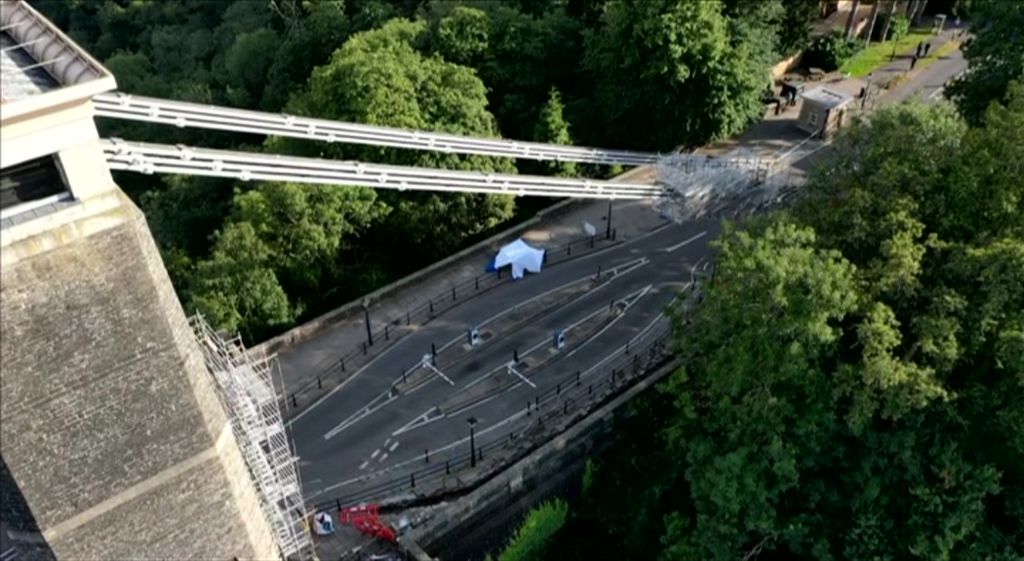 A drone shot showing the Clifton Suspension Bridge and a tent on a pavement