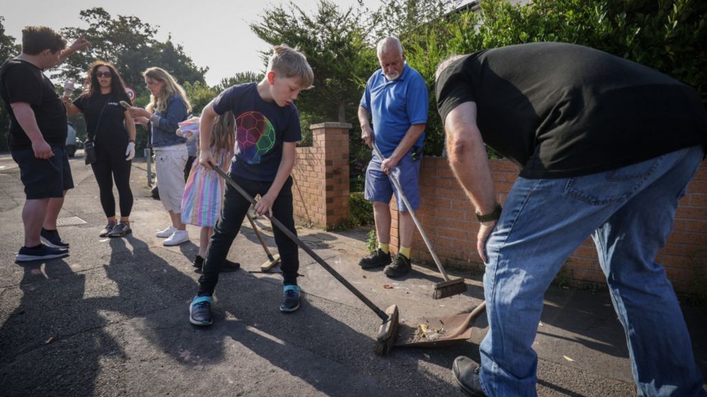 Volunteers in Southport help clean up debris left after violent scenes