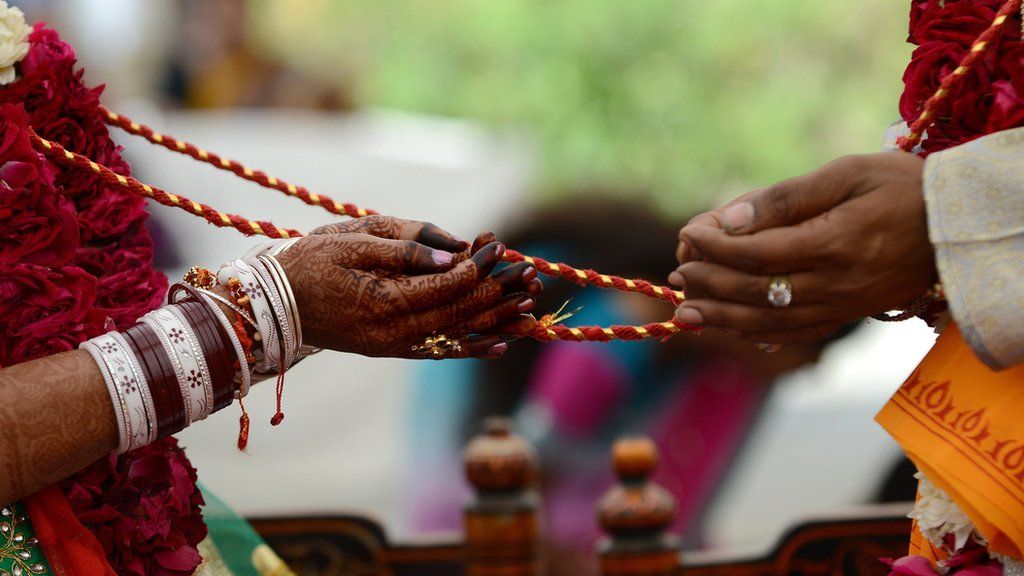 An Indian bridal couple participate in Hindu rituals during a mass marriage