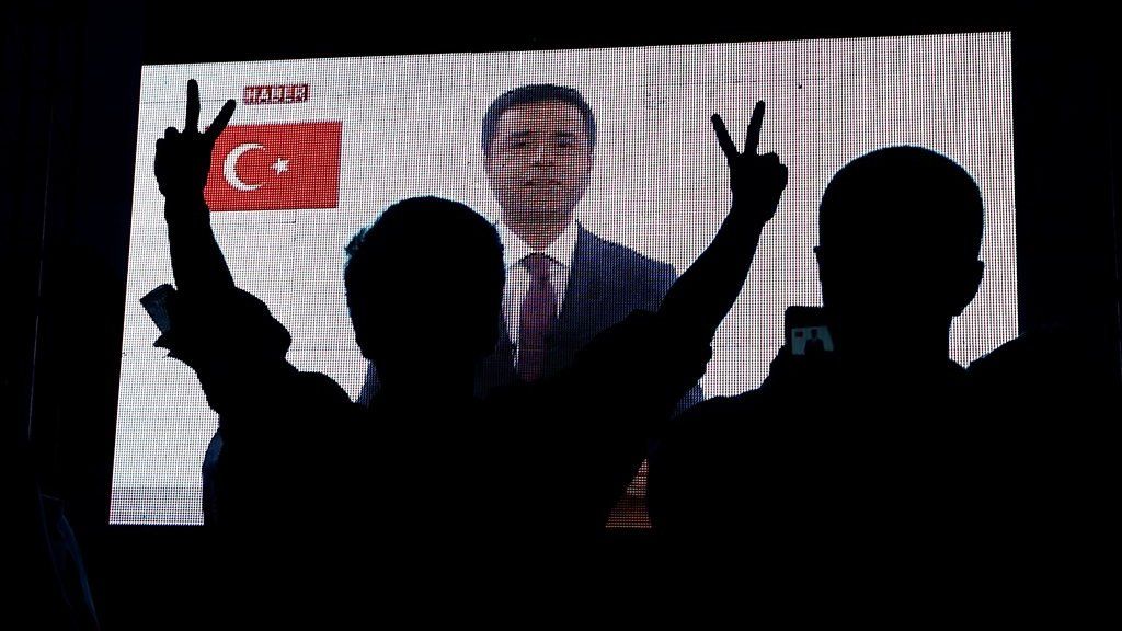 Selahattin Demirtas on screen with supporter in foreground