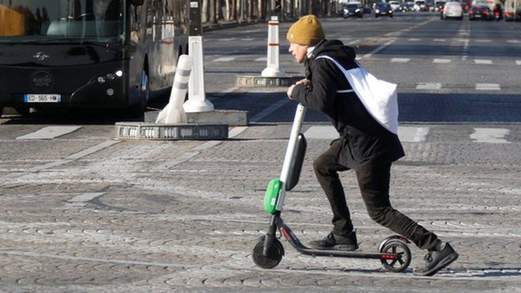 man rides scooter in Paris street