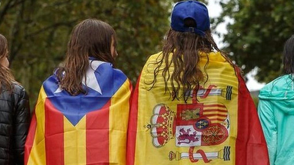 Girls stroll through the centre of Figueras with the Spanish and a pro-independence "Estelada" Catalan flag on 30 September 2017