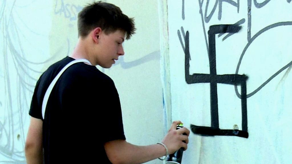 Klemens spray-painting over swastika