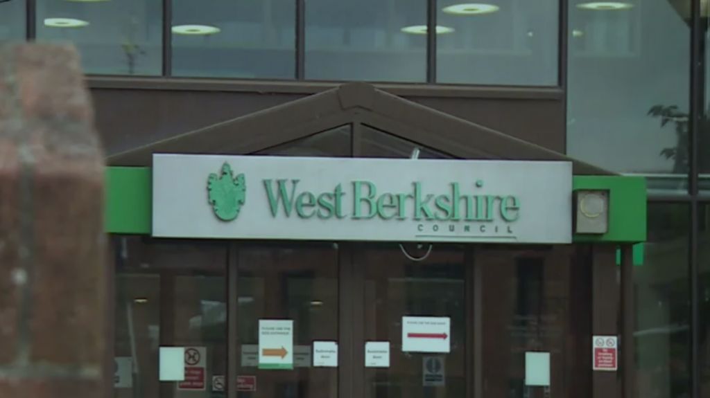 The exterior of West Berkshire Council Offices, including a large glass facade and a silver sign with the council's name in green letters.