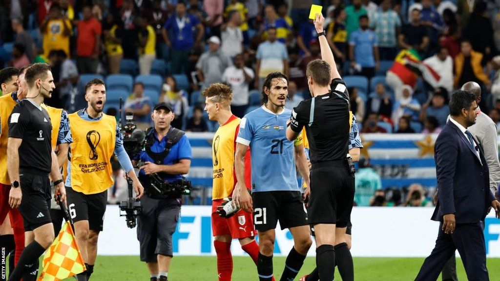 German referee Daniel Siebert shows a yellow card to Uruguay's Edinson Cavani after the end of the Qatar 2022 World Cup Group H football match with Ghana