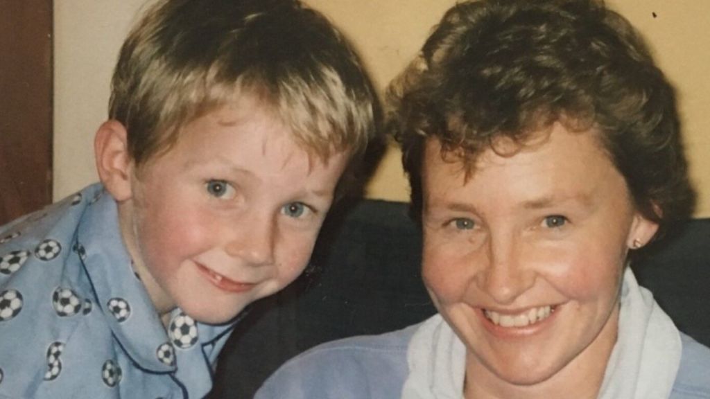 A young Mr Locke as a child with his mother, smiling at the camera.