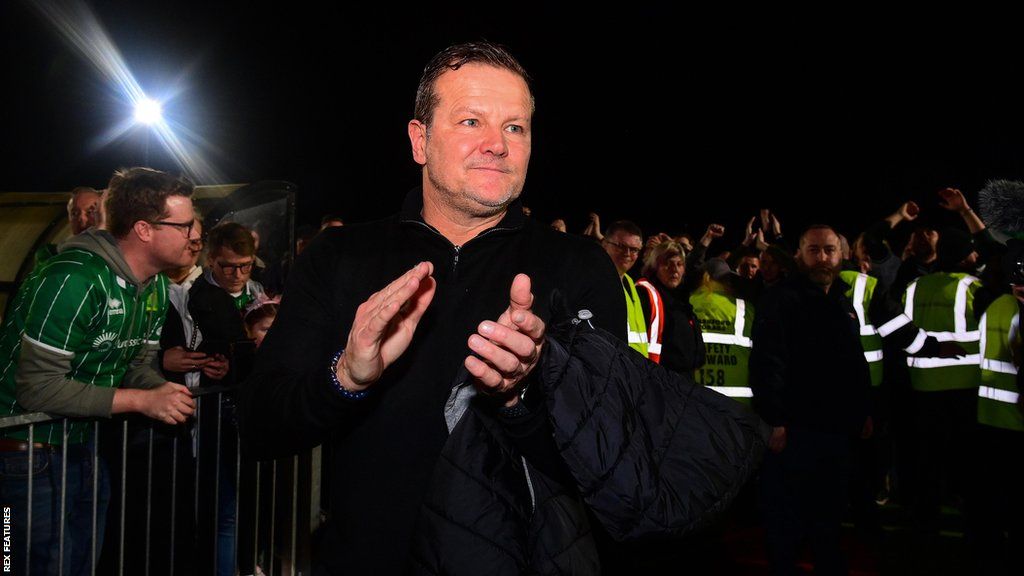 Mark Cooper claps on the pitch after the full-time whistle