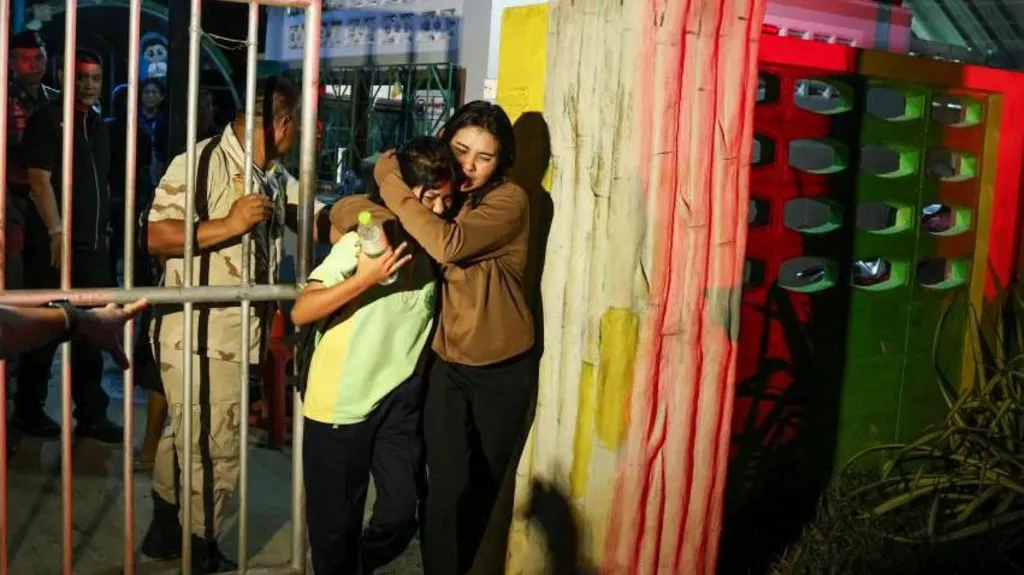 Two females hug as they leave the school where a siege happened 