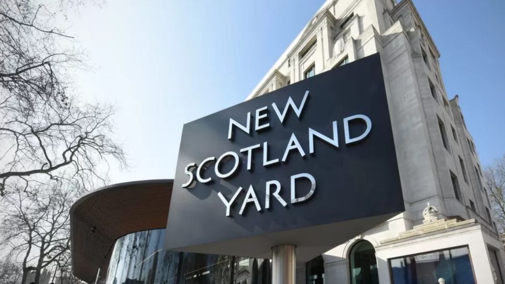 Stock photo of the famous New Scotland Yard triangle sign outside the headquarters of the Metropolitan Police.