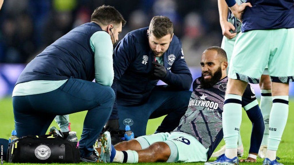 Brentford forward Bryan Mbeumo is treated after suffering an ankle injury at Brighton