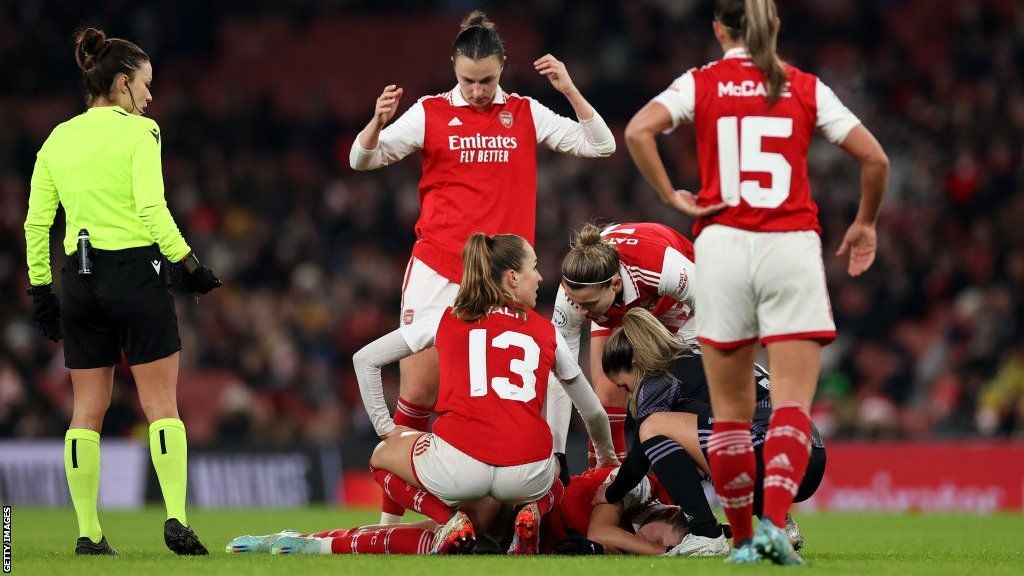 Team-mates surround Vivianne Miedema as she lies injured on the pitch