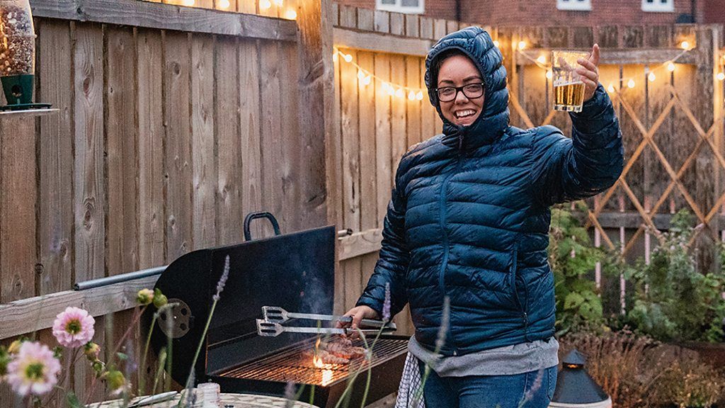 A woman doing a barbecue in the rain