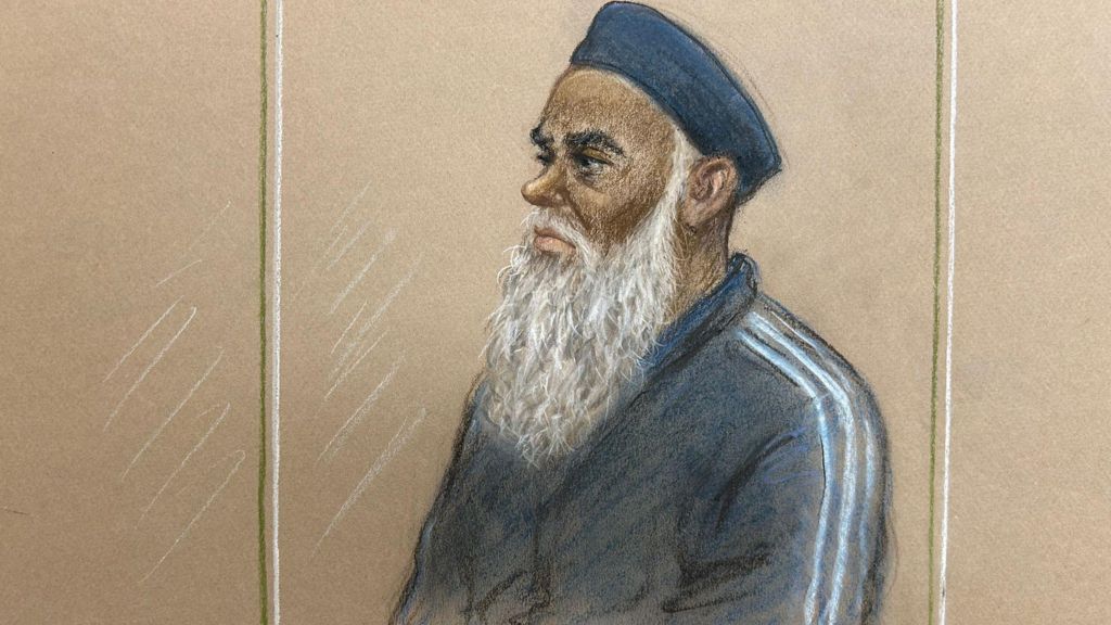 Court sketch shows a man in dock. He has a long, grey beard and is wearing a kufi