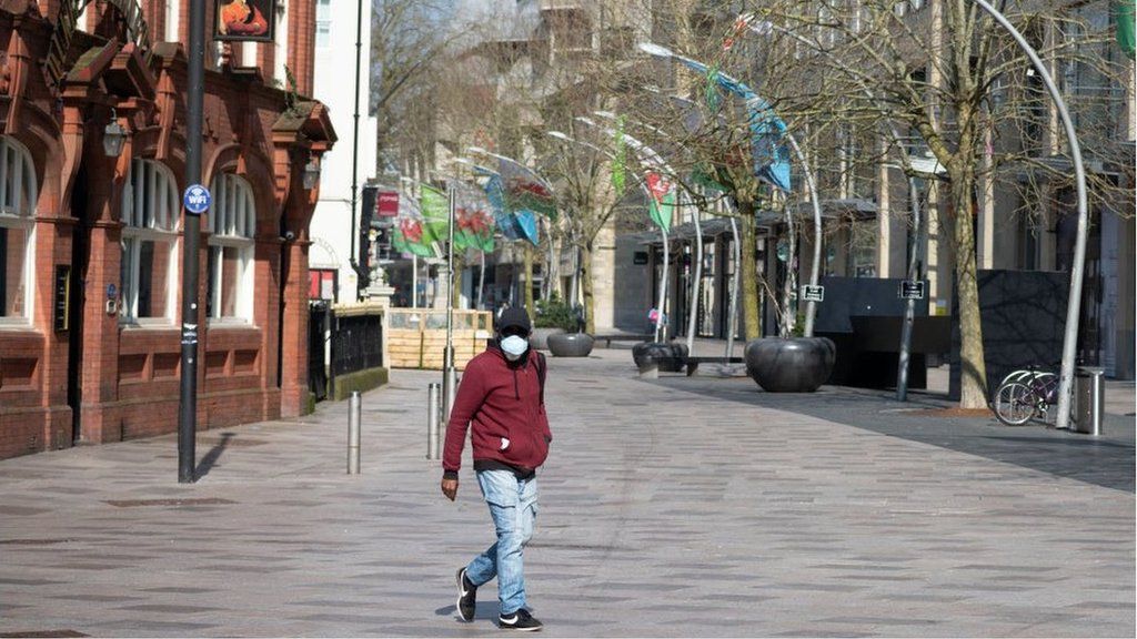 A man in a mask walking through Cardiff