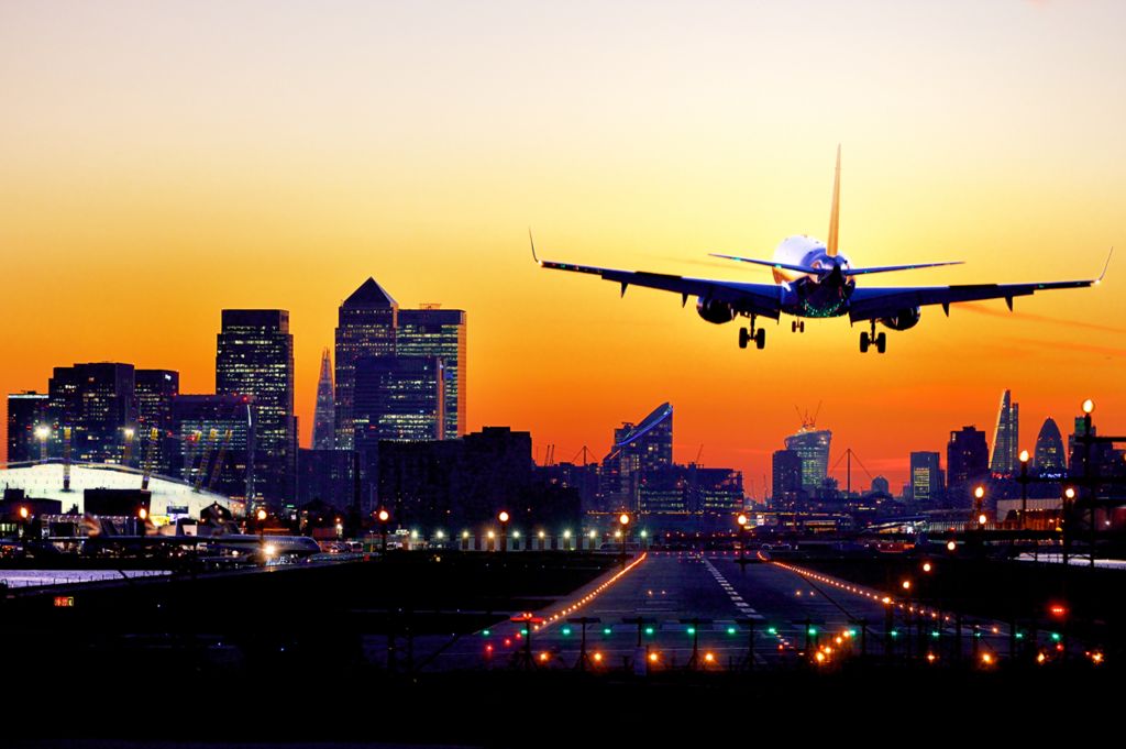 Plane coming into land at London City Airport at sunset